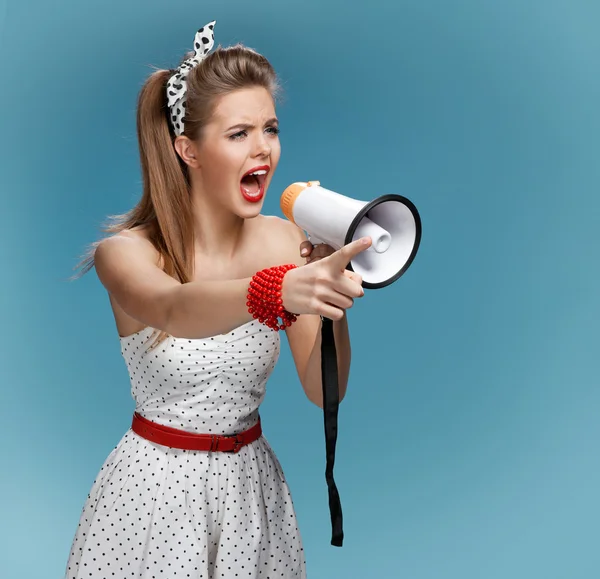 Angry pin-up girl shouting into a megaphone, mouthpiece, speaking trumpet. Filmmaking or film production concept