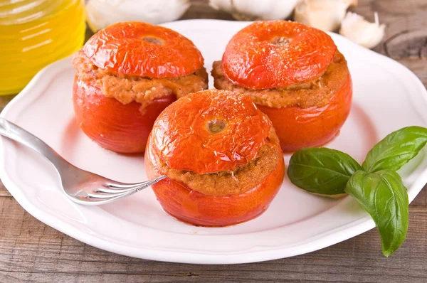 Stuffed tomatoes on a white plate.