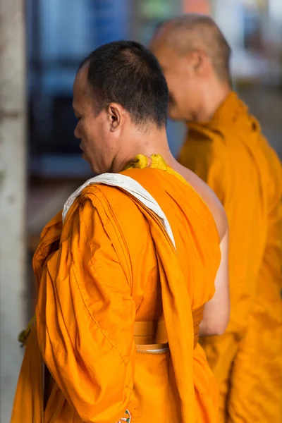 Two Thai monks standing and praying in Koh Chang Island.