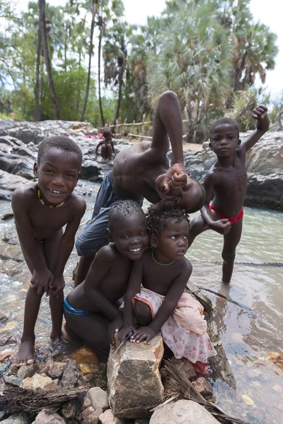 Himba children having fun in the river at the Epupa Falls river,