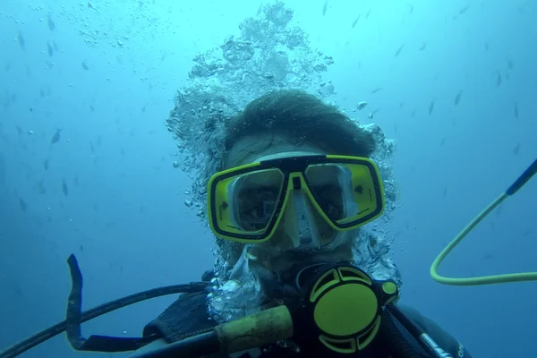 Underwater selfie of man diving scuba in Pacific Ocean