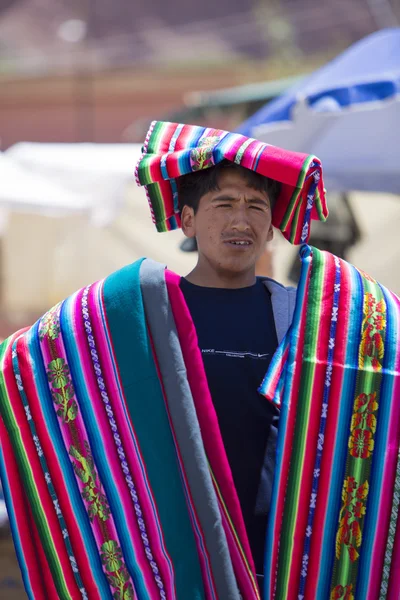 Colored fabrics on the shoulder of seller in the street, Tupiza