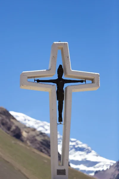 Religious cross with Aconcagua peak. Argentina