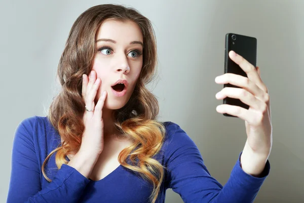 Shocked woman look at phone