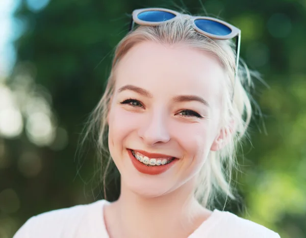 Blond teen girl with braces on her teeth
