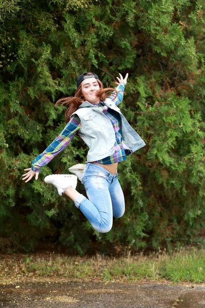 Teen girl jumping in park