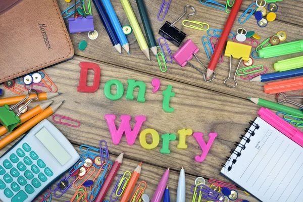 Don\'t Worry word and office tools on wooden table