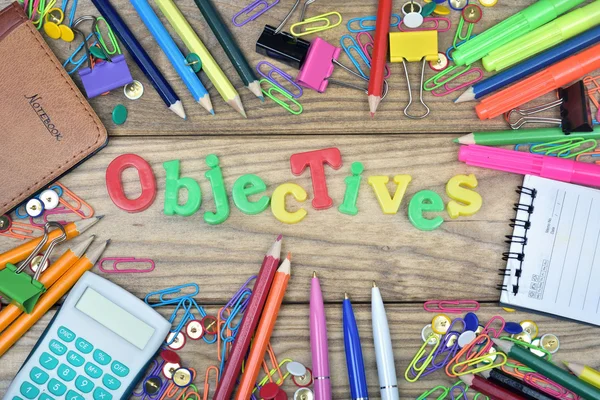 Objectives word and office tools on wooden table
