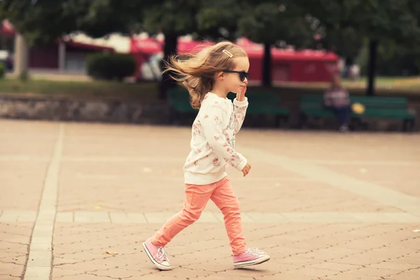 Stylish toddler girl model posing on street