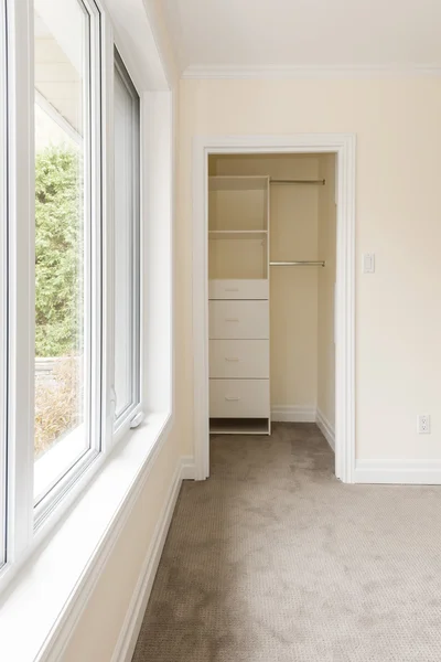 Empty bedroom with window and closet