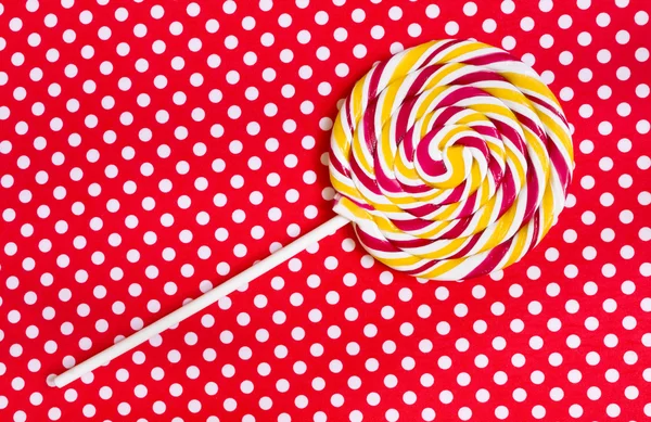 Lollipop on a red polka dot background