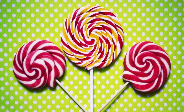 Retro looking photo of lollipops on a green polka dot background.