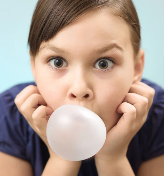 Little girl is blowing big bubble gum