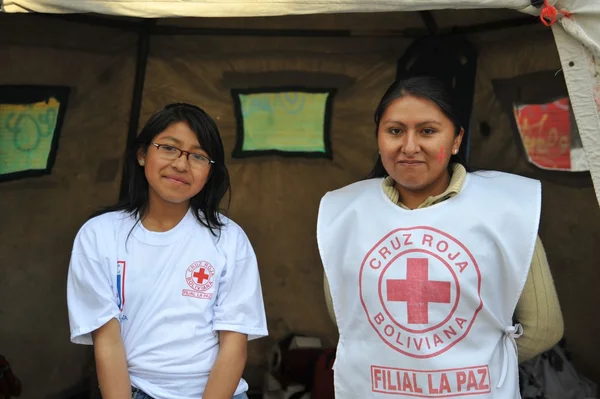 Activists of the red cross teach people first aid on a city street.
