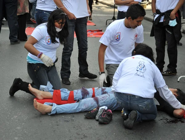 Activists of the red cross teach people first aid on a city street.
