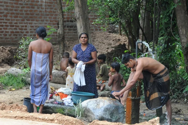 The inhabitants of the island  wash clothes and take water treatments at standpipes in the village street.
