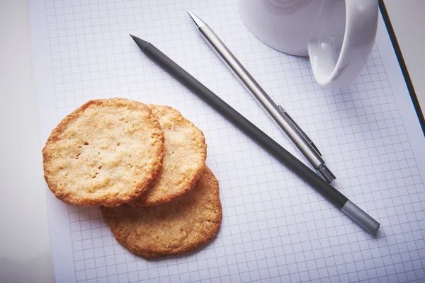 Cookies on notepad in office. Snack time in a work.