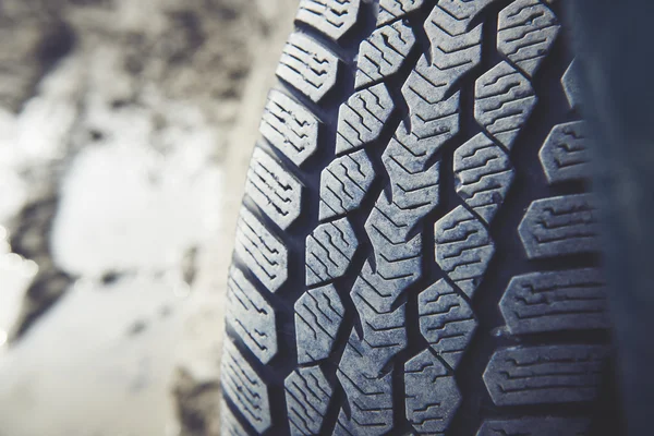 Dirty car tire on a dusty road. Look of tread dirty because of dust, sand and powder.