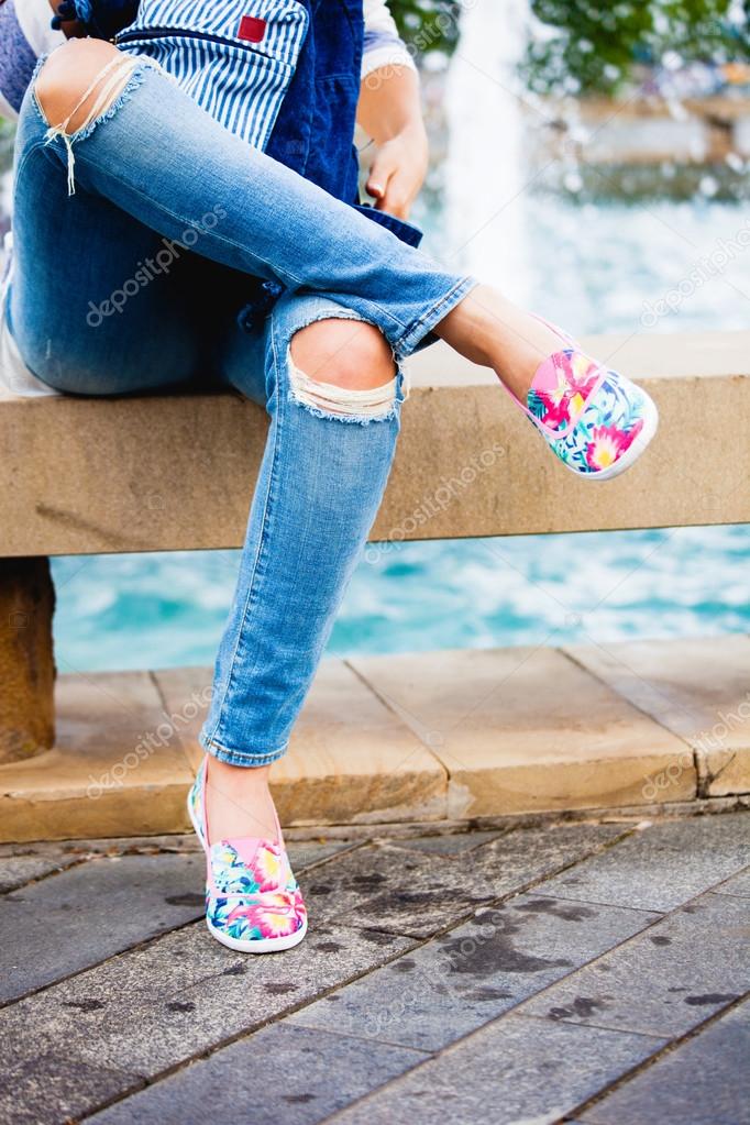 Chica en jeans azul y alpargatas sentado junto a fuente de la ciudad día de verano\u2014 Foto de cokacoka