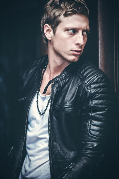 Young man portrait in leather jacket indoor shot