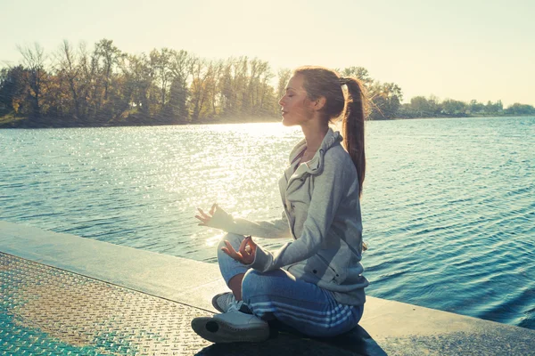 Woman meditate on lake