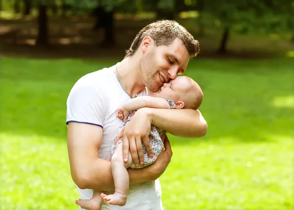 Dad and newborn daughter playing in the park in love