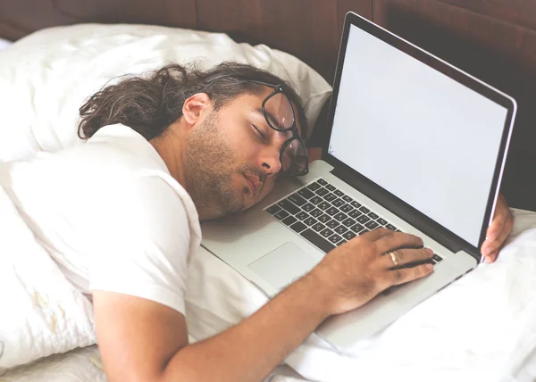 Freelancer man with laptop in the morning in his bed emotionally