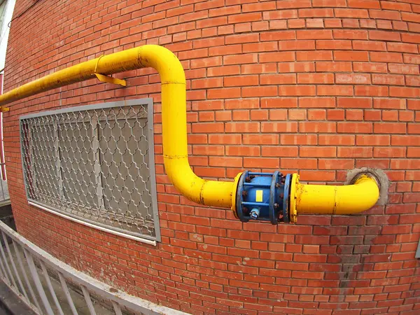 Wall of a building with a gas pipe and a large valve