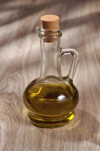 Olive oil in a glass bottle on a wooden table