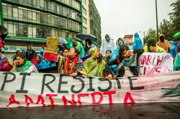 Quito, Ecuador - August 27, 2015: Group of angry mixed young people holding up banner and protesting angrily in city streets