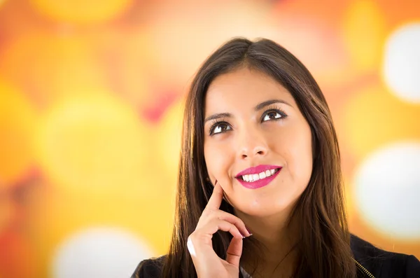 Headshot attractive brunette posing naturally with beauiful smile, colorful blurry background
