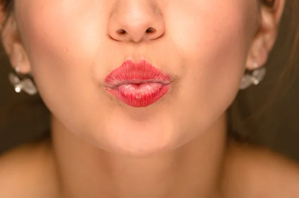 Closeup young womans mouth making kiss lips with red lipstick