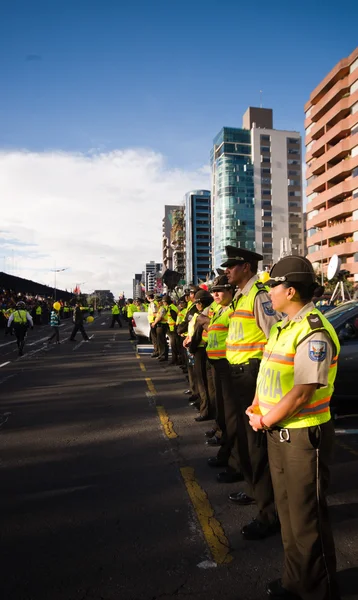 Quito, Ecuador - April 7, 2016: Police awaiting overlooking peaceful anti government protests in Shyris Avenue, beautiful blue sky and buildings background