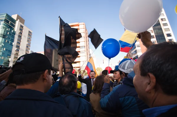 Quito, Ecuador - April 7, 2016: Group of people Holding protest signs, balloons with police and journalists during anti government protests in Shyris Avenue