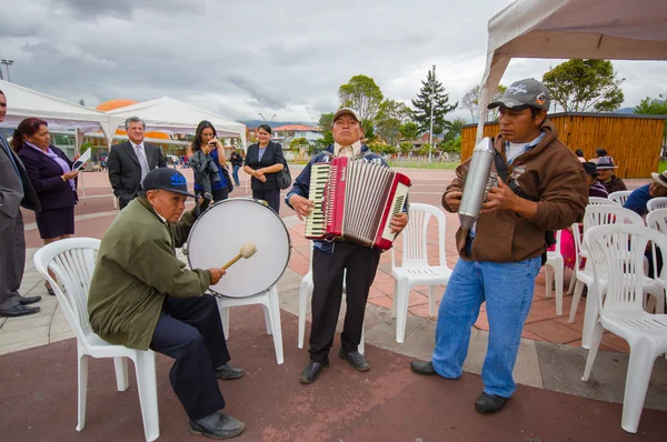 Cuenca, Ecuador - April 22, 2015: Local band of older people performing on city square using accordion, drums and metal shakers