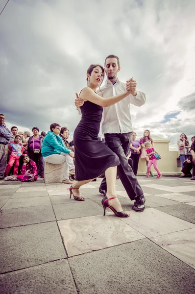 Cuenca, Ecuador - April 22, 2015: Couple performing latin dance styles on city square in front of small crowd