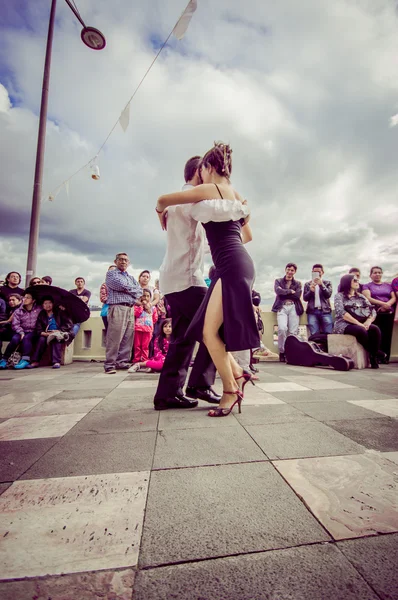Cuenca, Ecuador - April 22, 2015: Couple performing latin dance styles on city square in front of small crowd