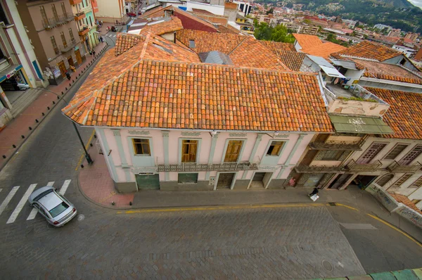 Cuenca, Ecuador - April 22, 2015: Typical townhouse with distinct red shingle rooftop as seen from high above, mild traffic outside