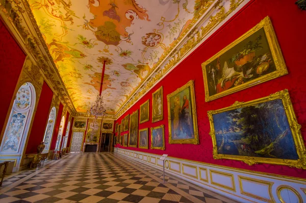 Schleissheim, Germany - July 30, 2015: Royal room inside palace with chandelier, amazing fresco painting, golden framed paintings and gold covered details
