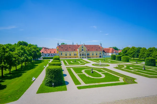 Schleissheim, Germany - July 30, 2015: Royal garden of palace property with incredible organized green bushes and gravel roads, majestic design, beautiful blue sky