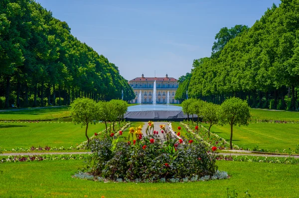 Schleissheim, Germany - July 30, 2015: Main palace building as seen from far distance through garden avenue, beautiful blue sky