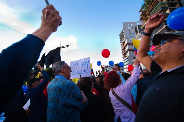 Quito, Ecuador - April 7, 2016: Group of people Holding protest signs, balloons with police and journalists during anti government protests in Shyris Avenue