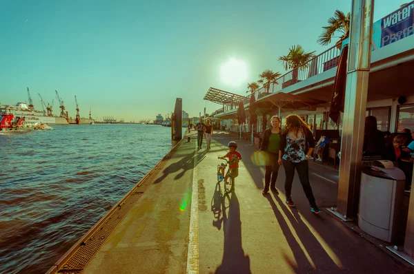 HAMBURG, GERMANY - JUNE 08, 2015: River pier on Hamburg, at the end of the day people can walk and go out with bycicles and childs