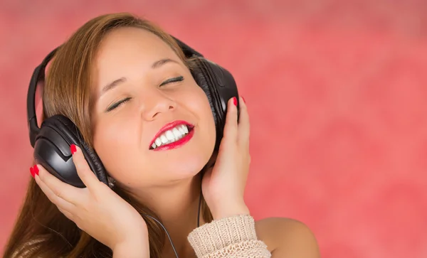 When a song is so good you can feel it, woman with headphones, eyes closed and hands on it