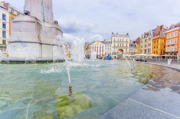 Lille, France - June 3, 2015: Beautiful Place Grande with its charming buildings and traditional european architecture sorrounding the plaza on a nice summer day, seen from fountain perspective
