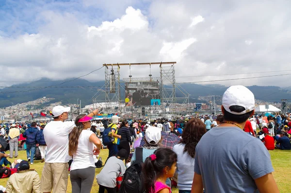 QUITO, ECUADOR - JULY 7, 2015: People very far from the scaffold looking and attending to mass on big screen