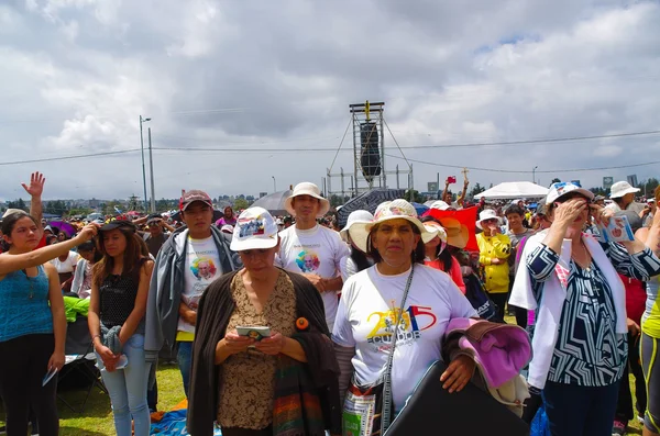 QUITO, ECUADOR - JULY 7, 2015: Unidentified people praying in pope mass event, persons with hat under the sun