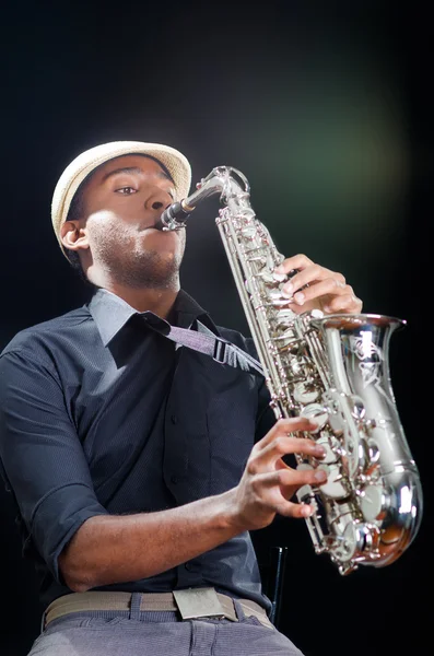 A nice view from below, black man is playing the saxophone. Professional hands with white hat