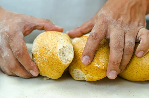 Bakers hands stacking fresh delicious buns of bread against each other