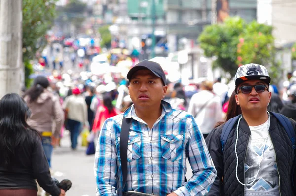 QUITO, ECUADOR - JULY 7, 2015: Two unidentified mens walking in the middle of the event, full of people. Pope Francisco mass